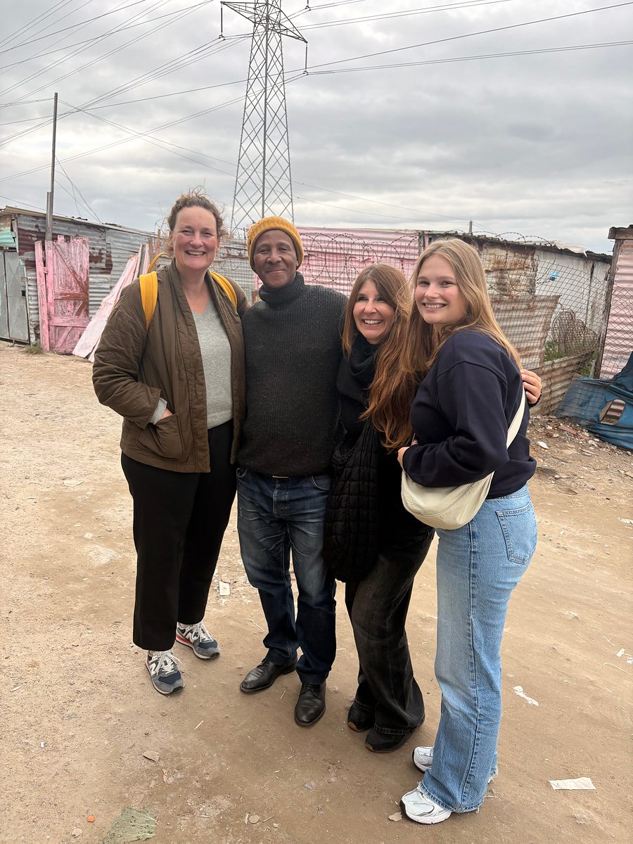 Four people standing together on a street in Khayelitsha